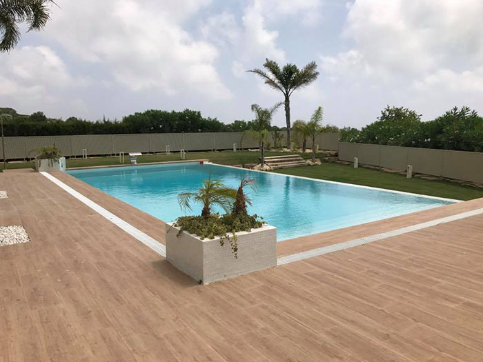 Piscina desbordante integrada con terraza y paisaje